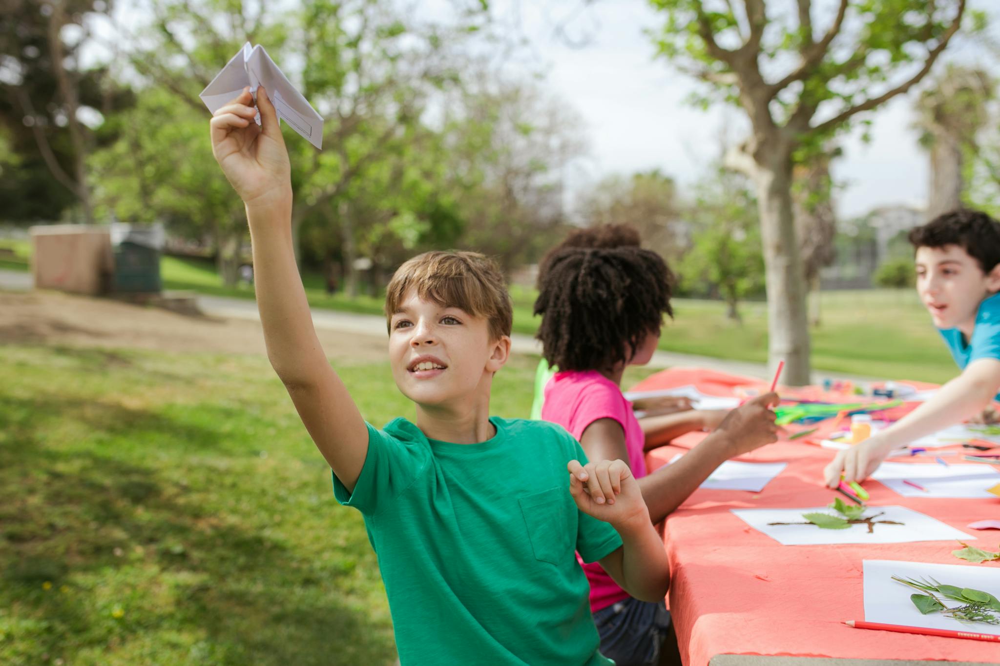 Children having fun making crafts outdoors at a vibrant summer camp setting.