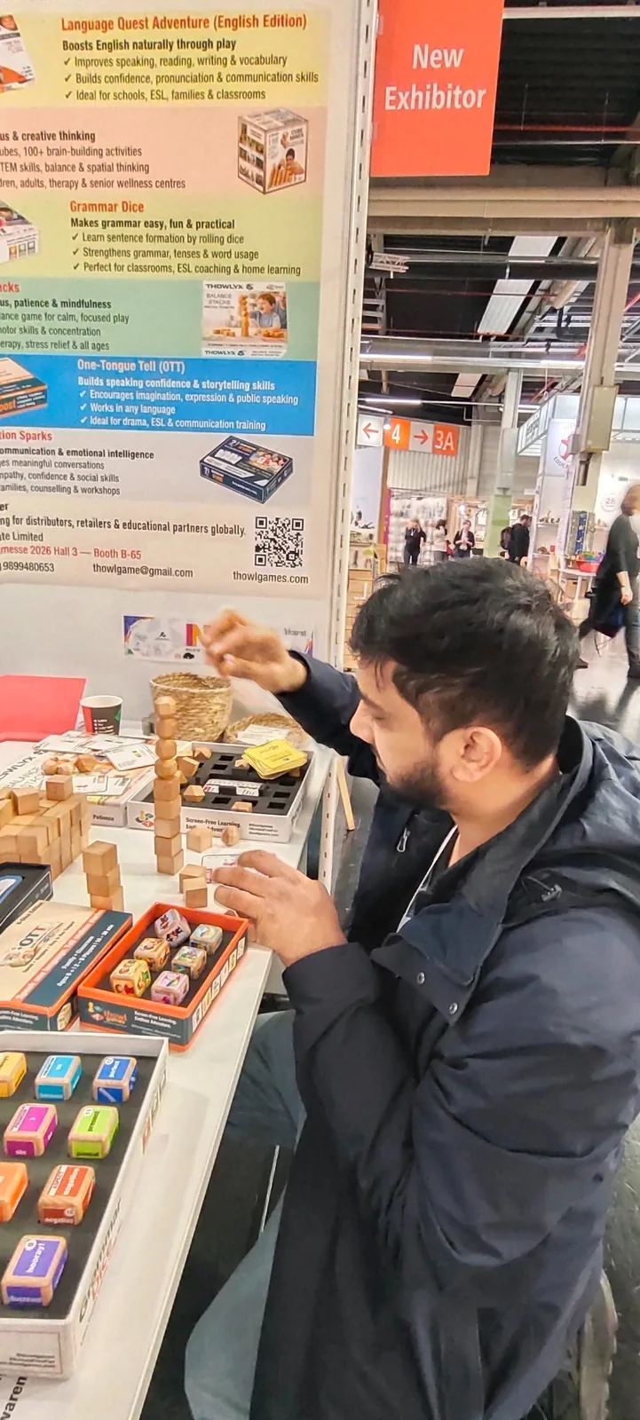 Visitor from Germany exploring several Thowl Games products at the booth